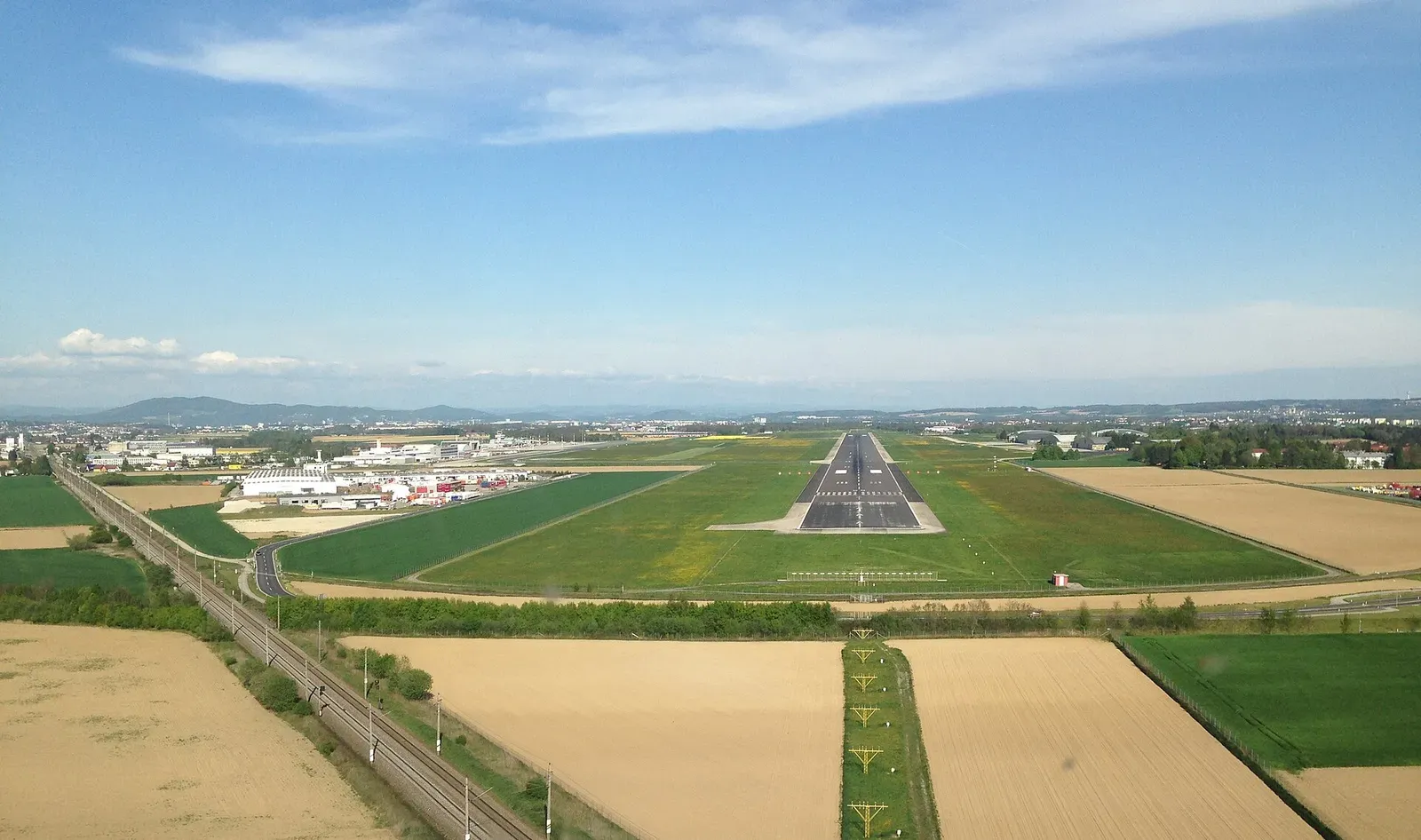 Flughafen Linz mit Start- und Landebahn (RWY 08). Links verläuft die Trasse der Westbahn
